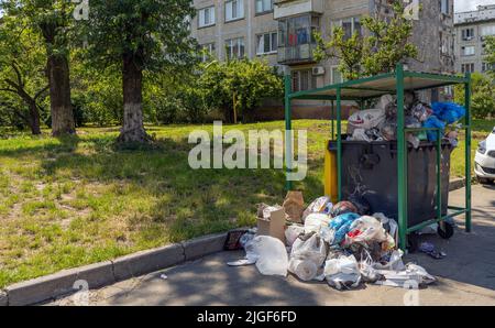 Poubelle débordante dans la ville. D'énormes piles de déchets à côté de la benne à ordures. Bac de recyclage débordant de déchets dans la rue Banque D'Images