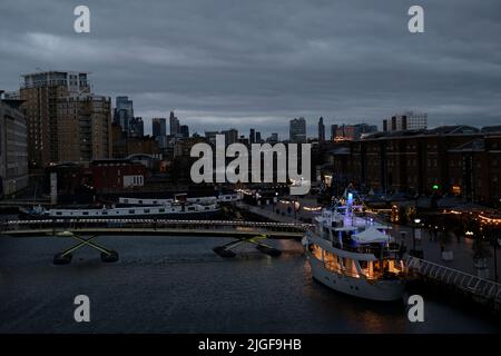 Boat converted into hotel in Canary Wharf's North Dock at twilight, with central London in the background Stock Photo