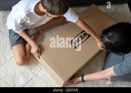 Vilnius, Lituanie - 7 juillet 2022 : mère et enfant assemblent les meubles Ikea à la maison. IKEA est le plus grand détaillant de meubles du monde, fondé en Suède Banque D'Images