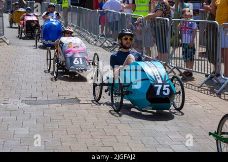 Ringwood, Hampshire, Royaume-Uni. 10th juillet 2022. Le Grand Prix de la voiture à pédales britannique a eu lieu pour la première fois dans la ville de Ringwood en 1987. L'événement attire désormais des milliers de spectateurs chaque année pour observer les « voitures » lorsqu'elles tournent autour de la piste en ville. Les foules affluent pour voir l'excitation par une chaude journée ensoleillée. Crédit : Carolyn Jenkins/Alay Live News Banque D'Images