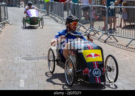 Ringwood, Hampshire, Royaume-Uni. 10th juillet 2022. Le Grand Prix de la voiture à pédales britannique a eu lieu pour la première fois dans la ville de Ringwood en 1987. L'événement attire désormais des milliers de spectateurs chaque année pour observer les « voitures » lorsqu'elles tournent autour de la piste en ville. Les foules affluent pour voir l'excitation par une chaude journée ensoleillée. Crédit : Carolyn Jenkins/Alay Live News Banque D'Images