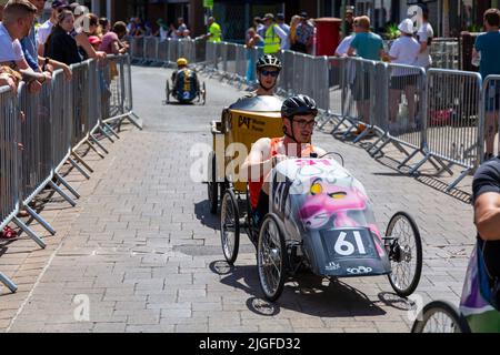 Ringwood, Hampshire, Royaume-Uni. 10th juillet 2022. Le Grand Prix de la voiture à pédales britannique a eu lieu pour la première fois dans la ville de Ringwood en 1987. L'événement attire désormais des milliers de spectateurs chaque année pour observer les « voitures » lorsqu'elles tournent autour de la piste en ville. Les foules affluent pour voir l'excitation par une chaude journée ensoleillée. Crédit : Carolyn Jenkins/Alay Live News Banque D'Images