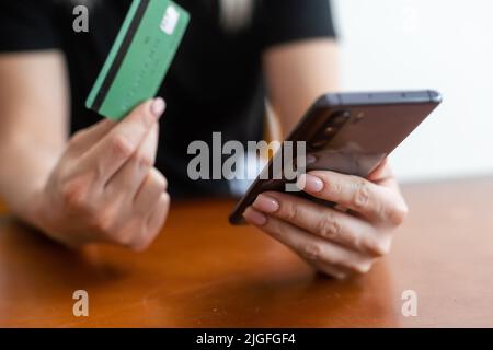 Femmes tenant une carte de crédit avec un smartphone pour l'application d'achat en ligne. Banque D'Images