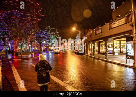 Belle vue sur la rue éclairée par les lumières de Noël, les gens marchent la nuit à travers le centre de Santa Fe Plaza, Nouveau-Mexique Banque D'Images