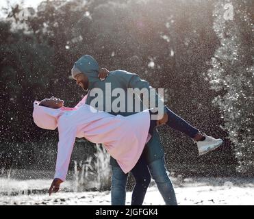 Notre histoire d'amour est ma préférée. Un jeune couple dansant sous la pluie. Banque D'Images