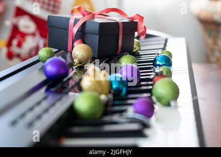 Composition du nouvel an sur un synthétiseur musical. Lumières d'une guirlande.Carte de vœux de joyeux Noël.Bonne année Banque D'Images