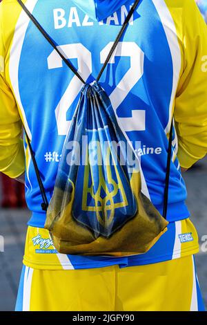 Une personne portant les couleurs de l'Ukraine et un sac à dos portant les armoiries de l'Ukraine (tryzub ou trident) lors d'une manifestation à Calgary Banque D'Images