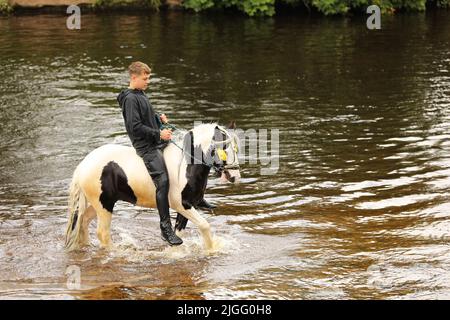 Un adolescent à cheval dans la rivière Eden, Appleby Horse Fair, Appleby dans Westmorland, Cumbria Banque D'Images