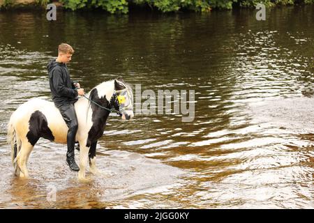 Un adolescent à cheval dans la rivière Eden, Appleby Horse Fair, Appleby dans Westmorland, Cumbria Banque D'Images