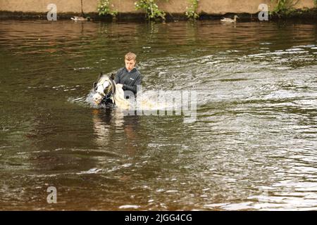 Un adolescent à cheval dans la rivière Eden, Appleby Horse Fair, Appleby dans Westmorland, Cumbria Banque D'Images