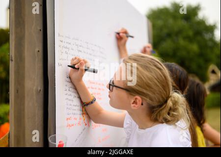 Les jeunes écrivent leurs prières sur un long rouleau de feuilles pendant Mladifest 2021 – le festival de la jeunesse – à Medjugorje. Banque D'Images