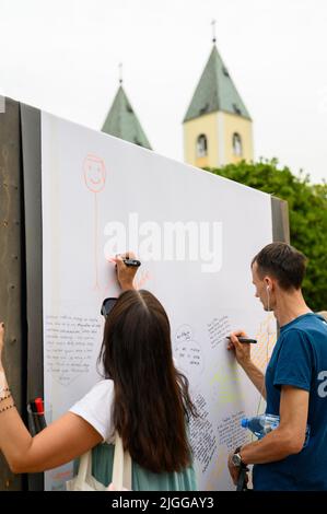 Les jeunes écrivent leurs prières sur un long rouleau de feuilles pendant Mladifest 2021 – le festival de la jeunesse – à Medjugorje. Banque D'Images