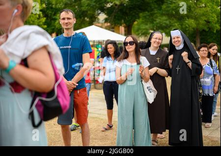 Deux religieuses souriantes, entre autres pèlerins, debout dans une rangée pour écrire une prière pendant Mladifest 2021 – le festival de la jeunesse – à Medjugorje. Banque D'Images