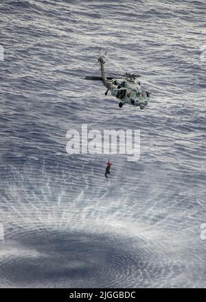 220703-N-DW158-1030 MER DES PHILIPPINES (3 juillet 2022) un buse de mer MH-60s attaché au Faucon doré de l'escadron de combat de la mer (HSC) 12, monte un membre de l'unité mobile d'élimination des munitions explosives (EODMU) 5, attaché au commandant de la Force opérationnelle (CTF) 70, Déployé à bord du seul porte-avions déployé par l’avant de la Marine américaine USS Ronald Reagan (CVN 76) au cours d’un exercice d’immersion dans une mine. Ronald Reagan, le navire amiral du Carrier Strike Group 5, fournit une force prête à combattre qui protège et défend les États-Unis, et soutient les alliances, les partenariats et les intérêts maritimes collectifs dans l'Ind Banque D'Images