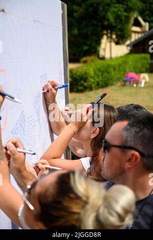 Les jeunes écrivent leurs prières sur un long rouleau de feuilles pendant Mladifest 2021 – le festival de la jeunesse – à Medjugorje. Banque D'Images