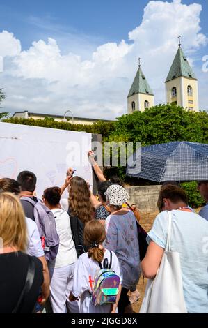 Les jeunes écrivent leurs prières sur un long rouleau de feuilles pendant Mladifest 2021 – le festival de la jeunesse – à Medjugorje. Banque D'Images