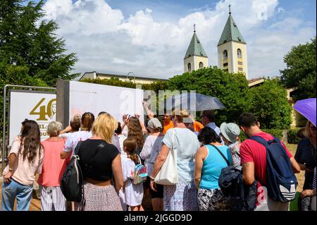 Les jeunes écrivent leurs prières sur un long rouleau de feuilles pendant Mladifest 2021 – le festival de la jeunesse – à Medjugorje. Banque D'Images