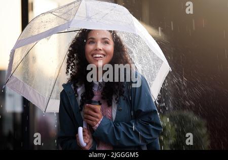 La pluie est une bénédiction d'en haut. Une jeune femme admirant la pluie dans la ville. Banque D'Images