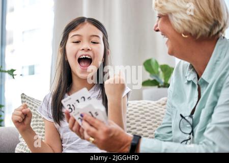 Shes vifiant ses tables de temps. Une petite fille et sa grand-mère jouant des cartes à la maison. Banque D'Images