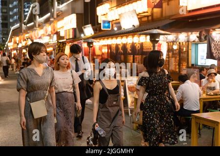 Tokyo, Japon. 30th juin 2022. Un groupe de femmes passe devant les restaurants japonais du parc Miyashita près de la gare de Shibuya dans le centre de Tokyo. Au sujet du 30 juin 2022 le ministre japonais de la Santé, du travail et du bien-être social, Shigeyuki Goto, a annoncé la position révisée du gouvernement sur le port de masque: « Même si vous passez devant d'autres personnes à l'extérieur, par exemple en marchant pour travailler, il n'est pas nécessaire de porter un masque facial tant qu'il n'y a pas ou peu de conversation. » En fait, dire que le port d'un masque facial à l'extérieur n'est plus recommandé. (Credit image: © Stanislav Kogiku/SOPA Images via ZUMA Press Wire) Banque D'Images