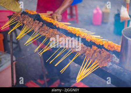 Grille sur un feu ouvert avec des bâtonnets de satay ou de sate. Traditionnel Satey est une brochette de viande. Le plat est un plat grillé originaire d'Indonésie mais très Banque D'Images