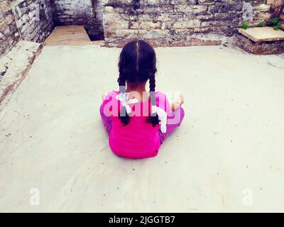 Une fille faisant du yoga dans la robe rouge mis sur un plancher de ciment Banque D'Images