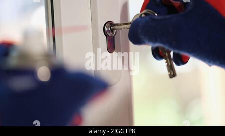 Le réparateur vérifie les clés et le verrou de la fenêtre en plastique Banque D'Images