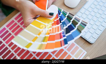 Un designer d'intérieur tient en main un ventilateur d'échantillons colorés Banque D'Images