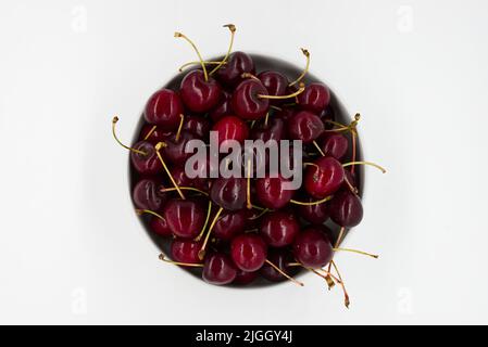 Cerises fraîches mûres dans un bol isolé sur fond blanc. Cerises italiennes Vignola. Banque D'Images