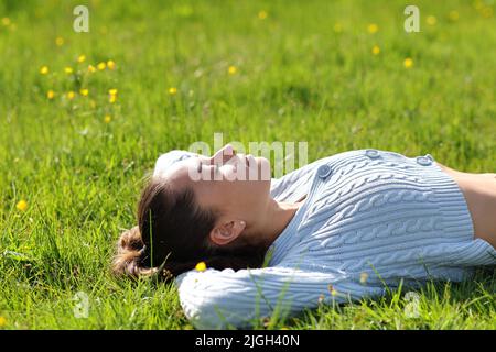 Femme se reposant et reposant couché sur l'herbe dans la montagne Banque D'Images