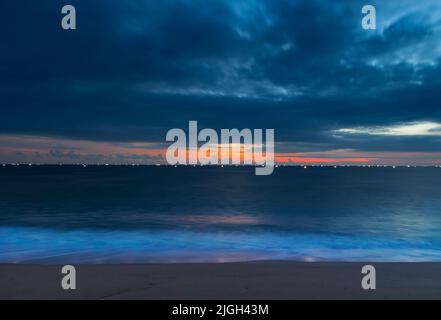 Le magnifique coucher de soleil avec des bateaux de pêche éclairés sur la mer. Thiruvananthapuram, Kerala, Inde. Banque D'Images