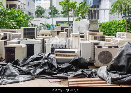 Beaucoup de climatiseurs empilés dans un tas à jeter à la décharge de recyclage. Pile de climatiseurs anciens et sales défectueuse et mise au rebut Banque D'Images