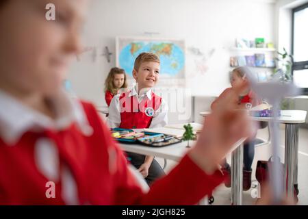 Les écoliers prêtant attention pendant la leçon en classe à l'école Banque D'Images