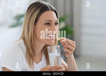 Belle femme millénaire prenant des médicaments et regardant l'espace de copie Banque D'Images