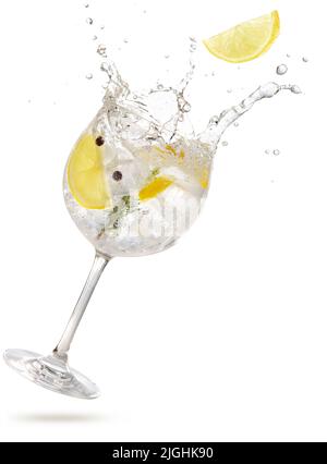 tranche de citron tombant dans un gintonic éclaboussant isolé sur blanc Banque D'Images