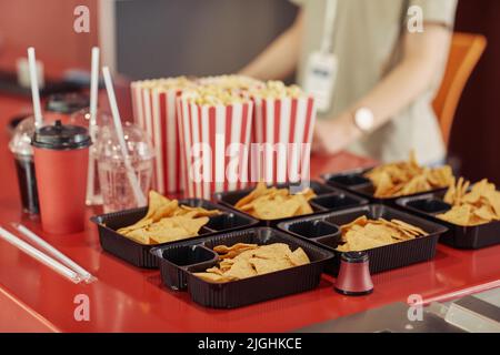 Gros plan du pop-corn, des jetons et du soda sur le comptoir de vente pour les spectateurs au cinéma Banque D'Images