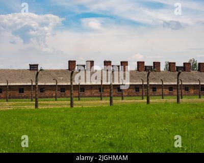 Oświęcim, Pologne - juin 2019 : casernes en briques rouges et clôture électrique dans le camp de concentration d'Auschwitz Birkenau. Camp d'extermination juif. Europe Banque D'Images