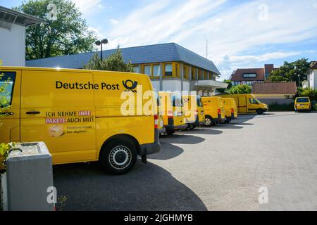 Oberkirch, Allemagne - 27 mai 2022: Rangée de multiples fourgonnettes électriques jaunes Volkswagen avec le logotype Deutsche post DHL - garée près du centre de distribution postal Banque D'Images