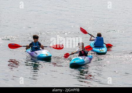 Southport, Merseyside. Météo Royaume-Uni 11 juillet 2022. Enfants ayant un temps d'éclaboussure. Kayakistes participant à des activités sportives juniors d'été avec l'organisation de canoë d'Aquaventure et de kayak de Pyranha à Marine Lake tandis que des températures chaudes de 33 degrés Celsius sont prévues. Crédit ; MediaWorld Images/AlamyLiveNews Banque D'Images