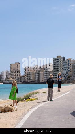 Famagusta, Chypre - 20 avril 2022 : les gens contemplent la plage de la ville abandonnée de la ville fantôme de Varosha Famagusta par une journée ensoleillée. Banque D'Images