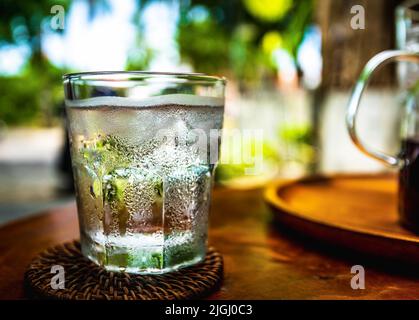 Glace eau froide assise dans un verre transparent avec de la glace et de la condensation sur les côtés. Banque D'Images