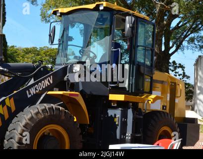 Tracteur avec chargeur sur roues de couleur jaune en exposition agricole au Brésil, Amérique du Sud en zoom, avec arrière-plan flou. Banque D'Images