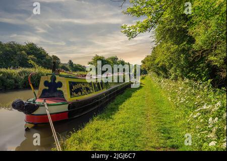 Promenade sur les canaux le jour de l'été avec un bateau étroit et de beaux paysages herbe verte arbres chemin de l'eau et ciel étonnant situé dans Brinklow Warwickshire Angleterre Banque D'Images