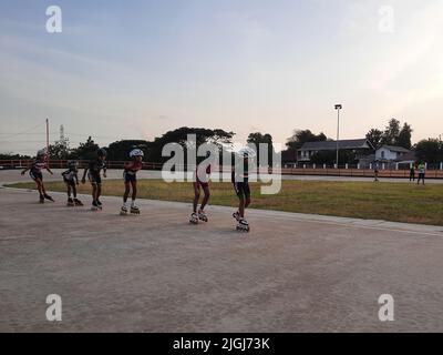 Jeune patineur mixte en ligne tout en s'entraîner sur une piste en plein air au stadion Pacar à Bantul, Yogyakarta, Indonésie. Banque D'Images