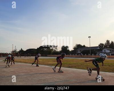 Jeune patineur mixte en ligne tout en s'entraîner sur une piste en plein air au stadion Pacar à Bantul, Yogyakarta, Indonésie. Banque D'Images