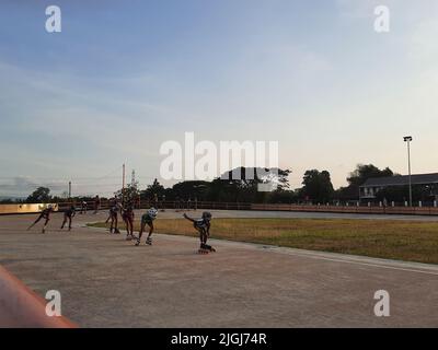 Jeune patineur mixte en ligne tout en s'entraîner sur une piste en plein air au stadion Pacar à Bantul, Yogyakarta, Indonésie. Banque D'Images