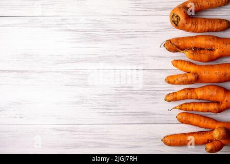 Vue de dessus gros plan de plusieurs carottes orange mûres laid se trouvent sur une surface en bois clair avec un espace de copie pour le texte. Mise au point sélective. Banque D'Images