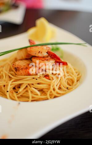 Une délicieuse portion de Spaghetti Aglio Olio aux crevettes, une recette traditionnelle de pâtes italiennes de Naples Banque D'Images