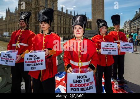 Londres, Royaume-Uni. 11 juillet 2022. Les membres du PETA (People for the Ethical Treatment of Animals) présentent une cascade sur le pont de Westminster vêtus de gardes de la Reine pour se couvrir de faux sang. Le retard de croissance est en avance sur un débat au Parlement au cours duquel les députés discuteront de remplacer par de la fausse fourrure les peaux utilisées pour les casquettes de la Garde reine. Credit: Stephen Chung / Alamy Live News Banque D'Images