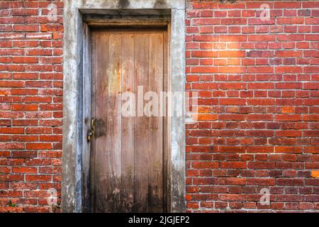 Une ancienne porte en bois avec le mur en brique rouge. (Bloc historique de Bopiliao dans le district de Wanhua, Taipei, Taïwan) Banque D'Images